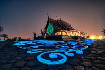 Wall Mural - Church temple with bodhi tree glowing and fluorescence painting on the floor at Wat Sirindhorn Wararam or Wat Phu Prao at Ubon Ratchathani