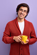 Young handsome smiling man drinking tea in morning, enjoy life