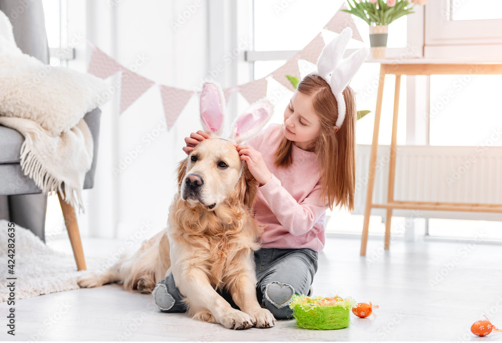Little girl with golden retriever dog at Easter - obrazy, fototapety, plakaty 