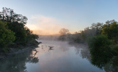 Early morning mist with sunrise behind trees in the Great Trinity Forest, Dallas, Texas