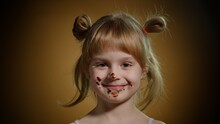 Joyful Child Kid With Dirty Face From Melted Chocolate On Dark Background In Studio. Satisfied Teen Girl Making Faces, Smiling. Addiction Of Sweets And Candies. Advertising Of Product