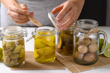 Homemade various pickled fruit in a glass jar with hand, Tropical preserved food, Food for digestion