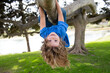 © Volodymyr - Little kid boy on a tree branch. Climbing and hanging child. Portrait of a beautiful kid in park among trees. Extreme kid sport. Child climbs a tree