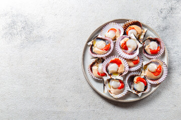 Wall Mural - Seafood. Shellfish. Raw scallops with lemon and cilantro on gray plate , gray background