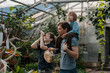 © Елена Григорович - Adventurous family inspecting tropical gallery in Botanical garden. Local travel