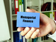 Business concept meaning Managerial Finance with phrase on the blue business card.