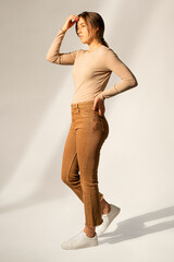 Wall Mural - Blonde woman in brown casual outfit posing