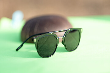 Black sunglasses classic design with black lenses and black frame shoot in a sunny day of summer closeup. Selective Focus. High quality photo