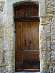 Wall Mural - old wooden door in town with red painted metal decoration on top