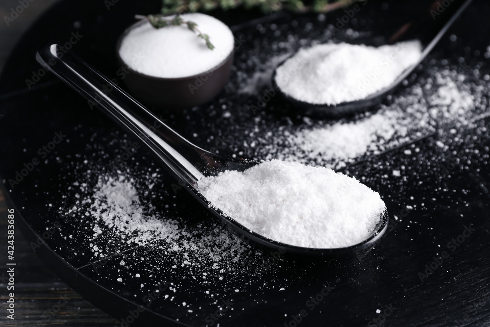Spoon of salt on dark background
