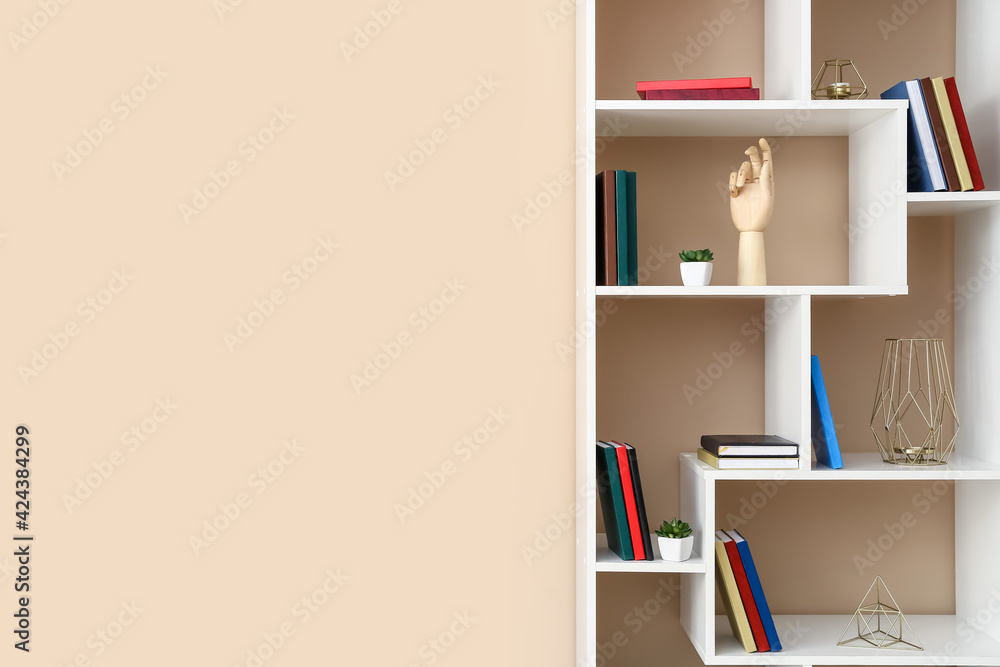Modern shelf unit with books and decor near color wall, closeup