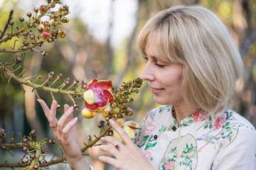 Wall Mural - Portrait of a young blonde girl with exotic flowers of Asian cannonball tree