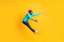 Full Size Profile Photo Of Brunette Optimistic Guy Jump Catch Wear Cap Spectacles Pullover Jeans Isolated On Yellow Background