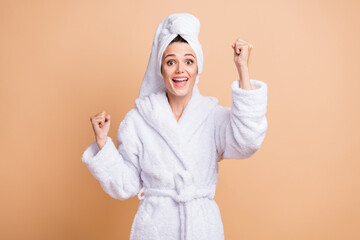 Portrait of lovely cheerful girl wearing white bathrobe rejoicing having fun isolated over beige pastel color background