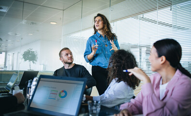 Businesswoman sharing new ideas with team in presentation