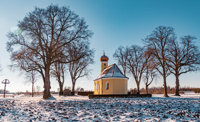 Beautiful winter landscape on a sunny day with a church near Wallersdorf, Bavaria, Germany