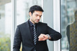 © eakgrungenerd - handsome businessman in black suit looking clock. checking time appointment.