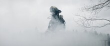 Silhouette Of American Female Firefighter In Traditional Helmet And Full Gear Standing In The Smoke. Shot With 2x Anamorphic Lens