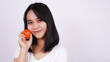 © HumbaFrame - Close up beautiful asian women with a tomato isolated on white background