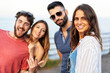 © Lomb - Portrait of young people having fun outdoors in the summer with the sea in the background. Togetherness concept, shallow depth of field with focus on the woman on the right