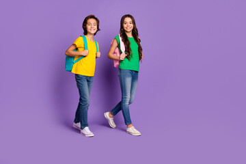 full size photo of cheerful boy and girl go school wear backpack education isolated on violet color 