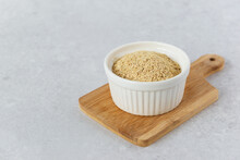 Inactive Yeast In A White Bowl On A Wooden Board.