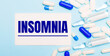 © Елена Дигилевич - Pills, ampoules and a white card with the text INSOMNIA on a light blue background. Medical concept