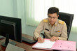 © ULTRAPOK - A Professional level Thai government officer, Civil servant signing the document on file.