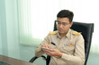 © ULTRAPOK - A Thai government officer, Civil servant is using the smartphone at the office.
