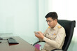 © ULTRAPOK - A Thai government officer, Civil servant is using the smartphone at the office.
