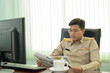 © ULTRAPOK - A Thai government officer, Civil servant is reading the newspaper in the morning at office.