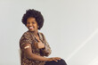 © Studio Romantic - Vaccinated young smiling african american woman with medical patch on hand showing thumbs up gesture approving Covid-19 vaccination studio portrait. Antiviral immunization promotion concept