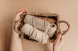 Women's hands holding the basket with cotton yarn. Cotton yarn for macrame in a rectangular basket.