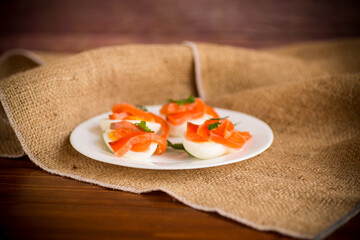 Wall Mural - halves of boiled eggs with pieces of salted salmon