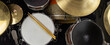 Musical instruments close up banner. Beautiful snare drum and hi-hat cymbals with drummer holding drumsticks. Modern drum set. Music shop.