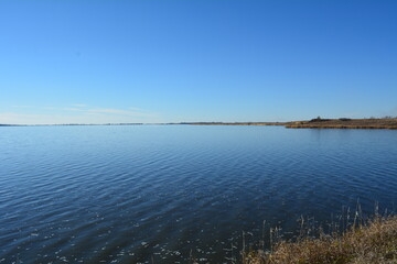 Blue lake disappears into the blue horizon of the sky