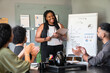 © Vergani Fotografia - black business woman giving flipchart presentation in the office. .