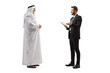 Full length profile shot of a young businessman talking to a mature arab man