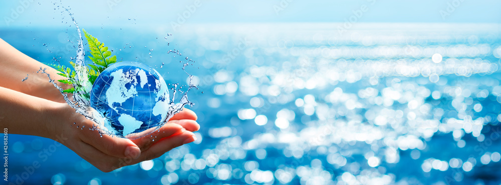 Environment Concept - Hands Holding Globe Glass In Blue Ocean With Defocused Lights - obrazy, fototapety, plakaty 