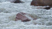 Water Flowing Into The River Among Rocks In Slow Motion