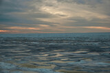 Fototapeta Morze - icy beach on the background of the sunset