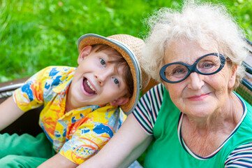 Wall Mural - Heppy Grandmother and her grandson face to face in embrace. Emotional portrait closeup. Family values, love, trust, relationships. Elderly woman, a boy spend leisure time together. Springtime. Family