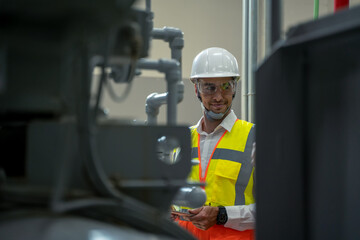 Fototapete - Portrait of electrician engineer use tablet computer taking notes at control room in factory.