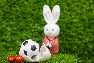 Wall Mural - Soccer ball for Easter Holiday with Easter eggs decoration on green grass