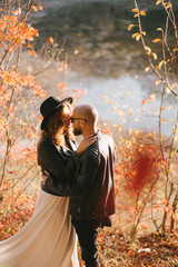 Wall Mural - Couple in love wearing fashionable clothes walking in beautiful autumn forest.