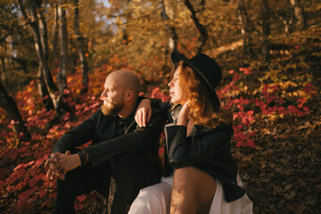 Wall Mural - Couple in love wearing fashionable clothes walking in beautiful autumn forest.