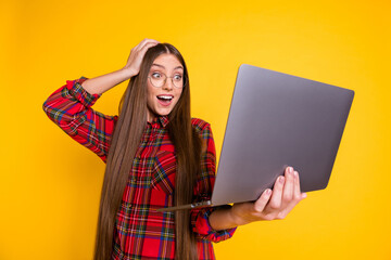 Canvas Print - Portrait of beautiful trendy cheerful amazed girl using laptop having fun web education isolated over bright yellow color background