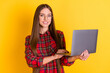 Portrait of nice optimistic brunette long hairdo lady hold laptop wear spectacles red shirt isolated on vivid yellow color background