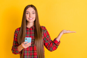 Poster - Portrait of nice optimistic brunette long hairdo lady hold telephone empty space wear red shirt isolated on vivid yellow color background