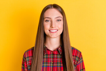 Poster - Photo of adorable young girl beaming smile look camera wear plaid clothing isolated on yellow color background